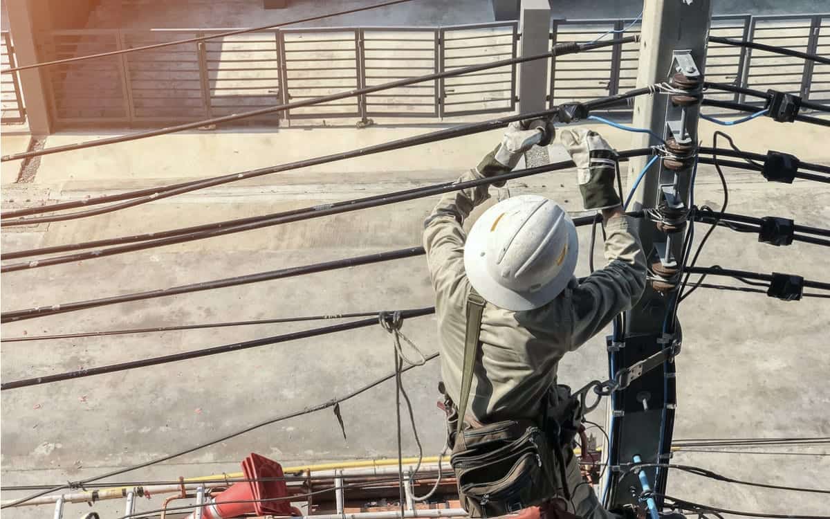 Electrician working on electric poles to install power lines