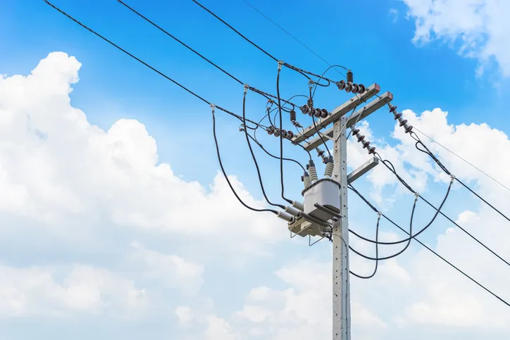 An electrical utility pole in Quebec under a blue sky that needs to follow parts of the Canadian Electrical Code